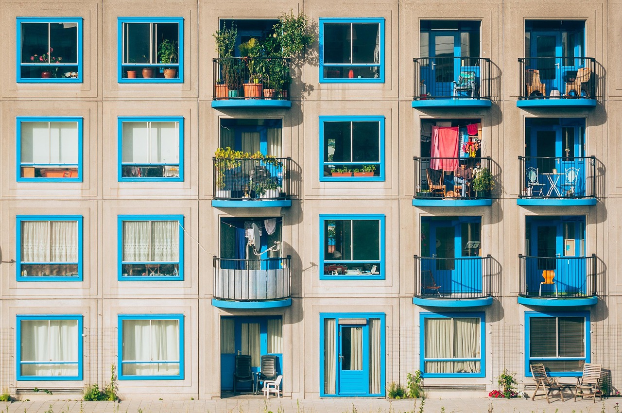 Blue windows of apartments in a block with balconies