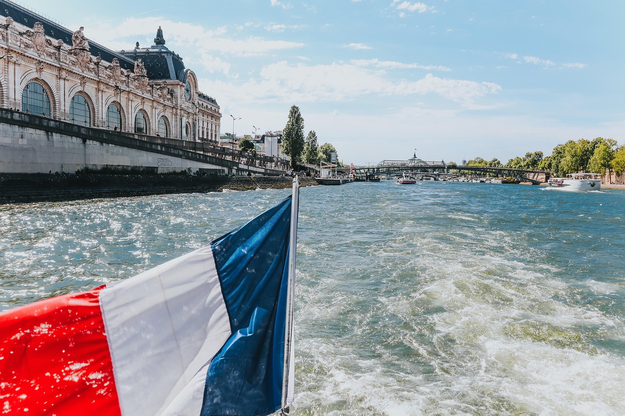 A boat flying the French flag sailing down the Seine river in Paris.