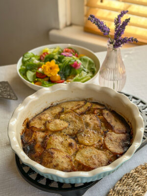 Welsh onion cake in a pie dish (although a cake tin may also be used), with a side salad behind it.