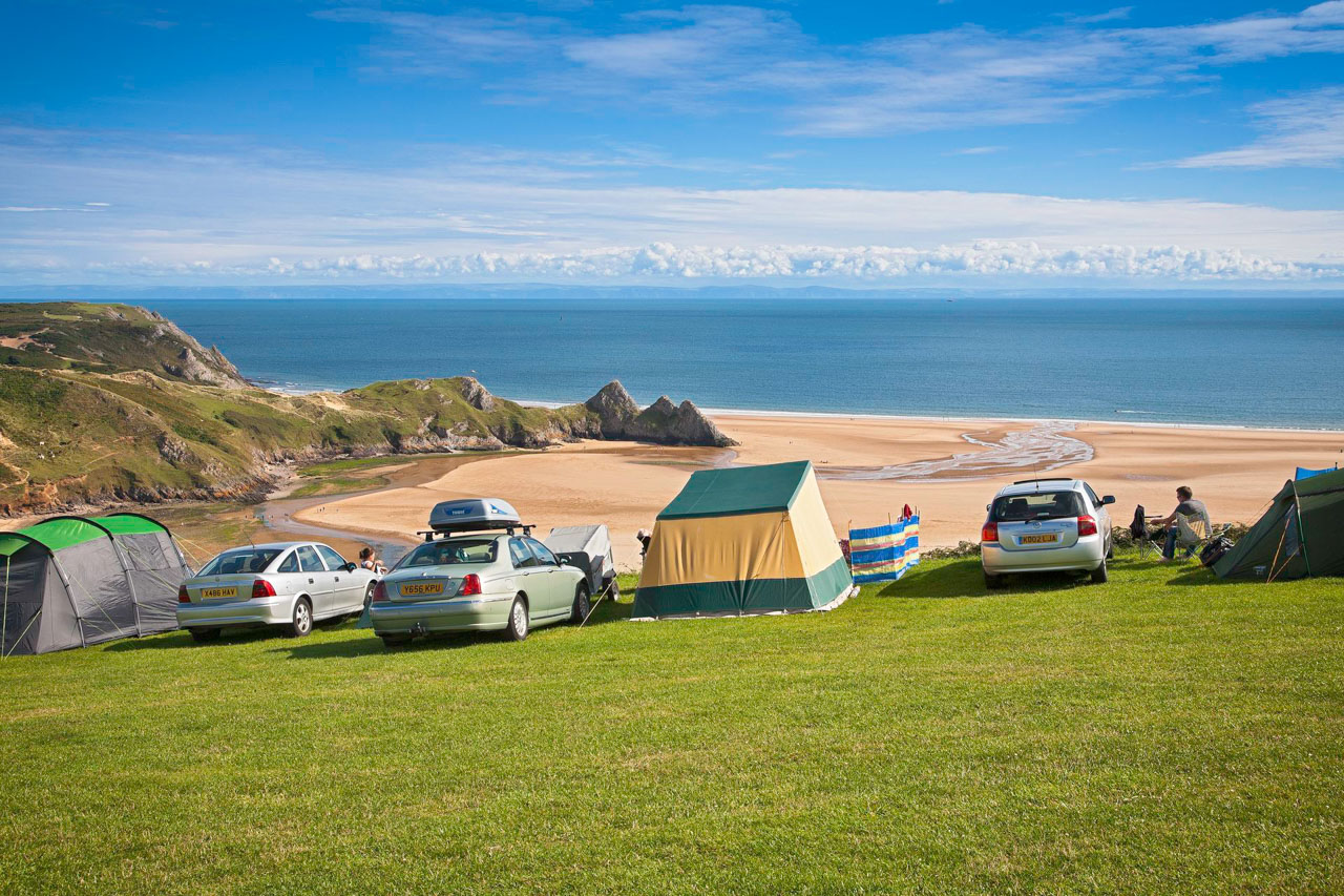 Cars and tents overlooking beach Three Cliffs Bay Holiday Park Gower Peninsula County of Swansea South Camping and Caravanning Accommodation
