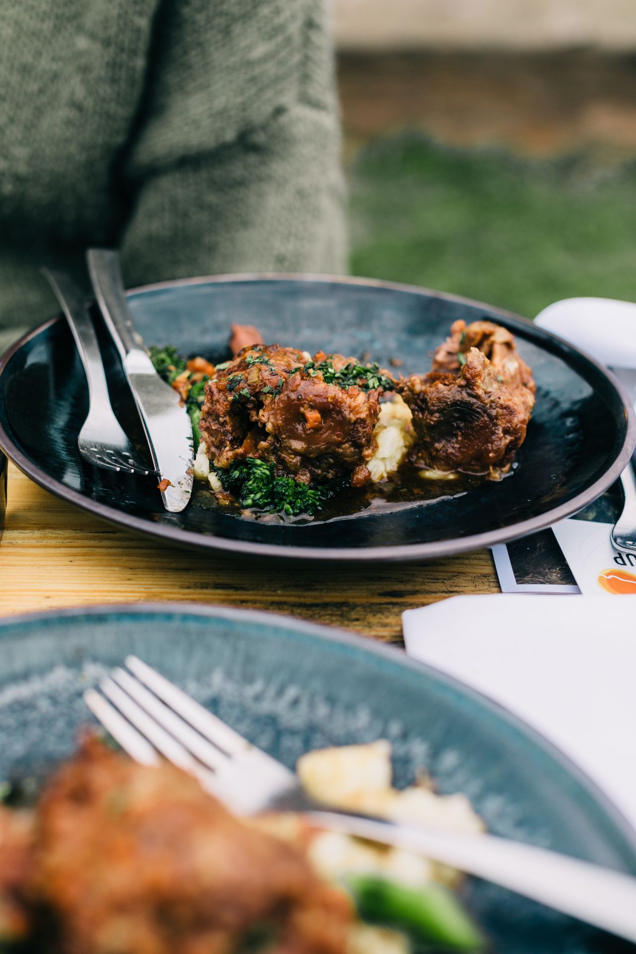Delicious gourmet meal with tender meat and greens served alfresco on a patio.