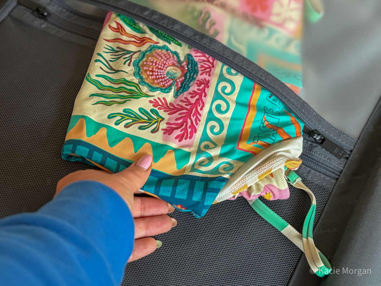 Placing a swim-suit inside the wet-dry pouch