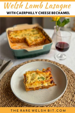 Welsh Lamb lasagne served in a pasta dish, with the lasagne dish next to a glass of red wine and a yellow rose in the background.